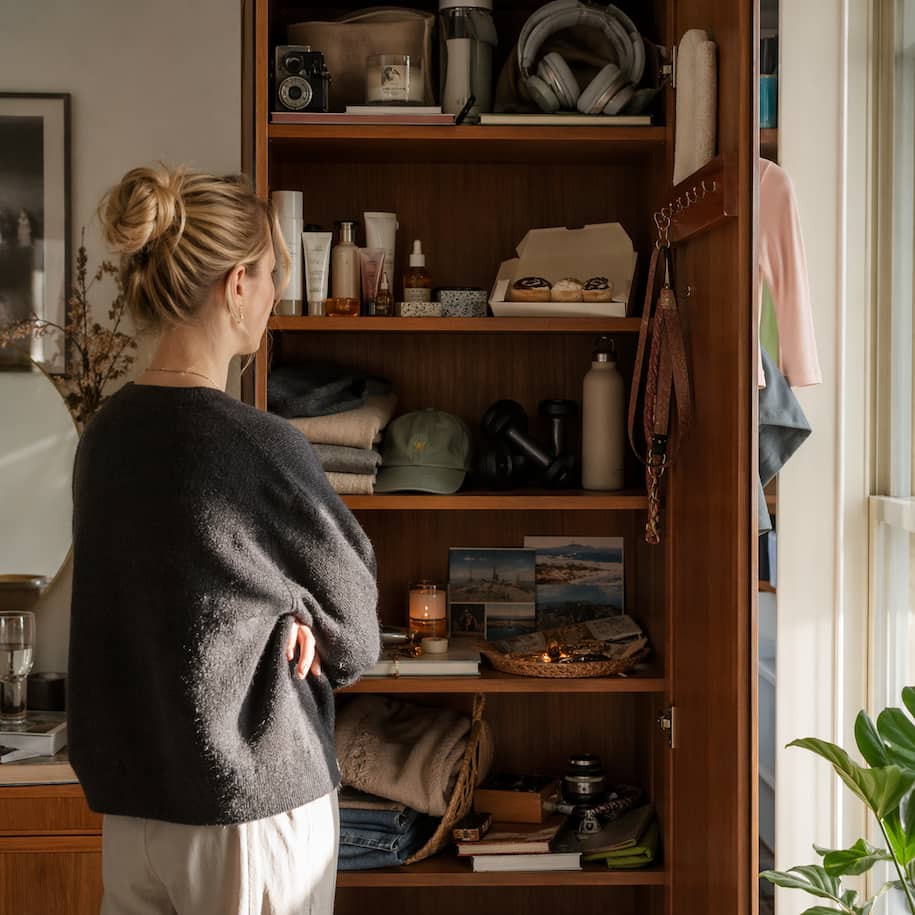 Öppet skåp med resebilder, hudvård, hörlurar och träningssaker som speglar hur Instagrams Explore-sida avslöjar vanor
