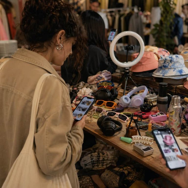 Någon som letar bland gamla trendprylar på ett second hand-bord medan flera mobiler visar samma estetik i nya versioner